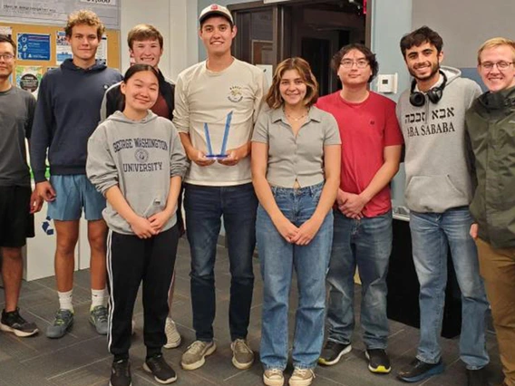 Students in different colored shirts pose for a photo.