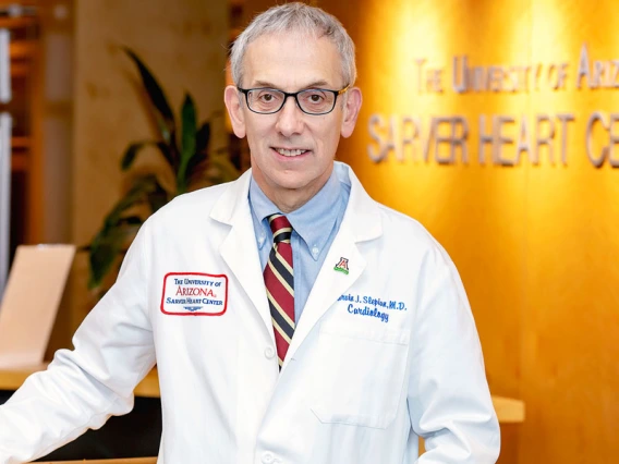 Marvin J. Slepian stands in front of a Sarver Heart Center sign wearing a lab coat