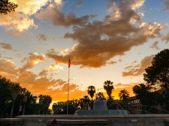 The sun sets over a fountain on the UA campus.