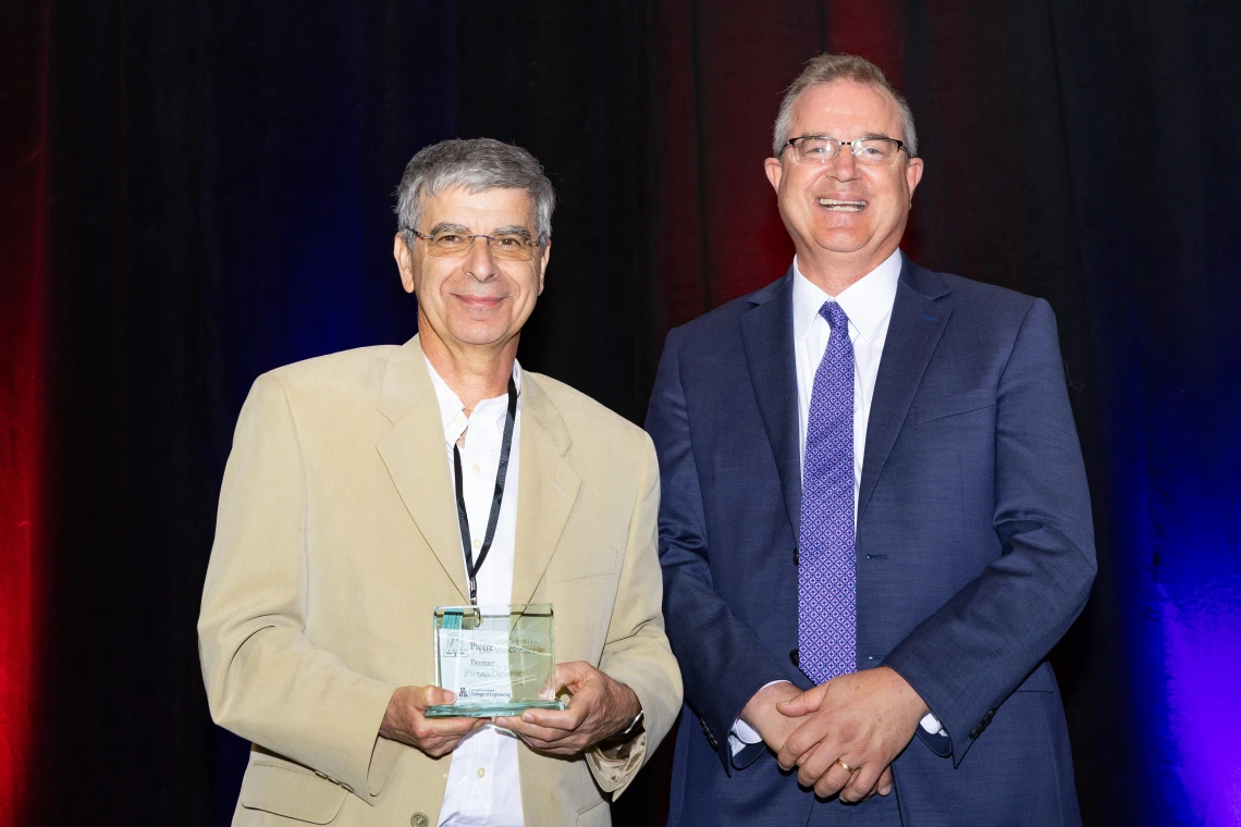 Deymier and Hahn pose with a glass award.