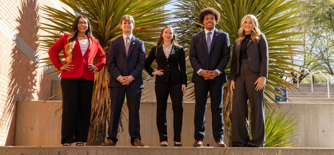 students in suits pose for a photo
