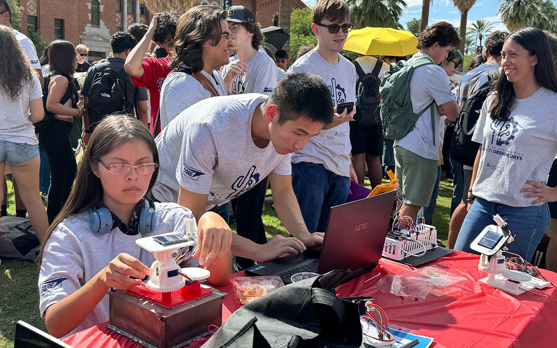 Students crowd around self-made solar trackers.