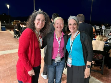 Three women pose for a photo.