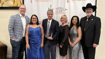 People holding an award pose for a photo.