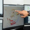 A person points at a computer screen.